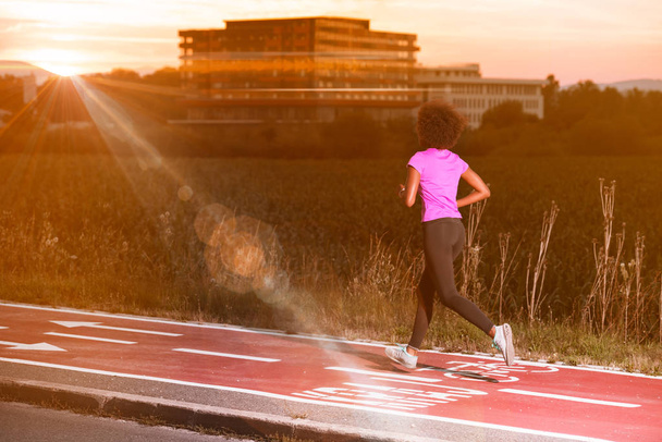 a young African American woman jogging outdoors - Foto, Imagen
