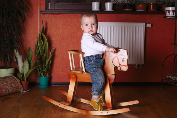 söpö poika ratsastus puinen hevonen
 - Valokuva, kuva