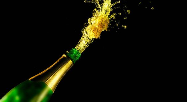 Feierthema mit spritzendem Champagner, isoliert auf schwarzem Hintergrund - Foto, Bild