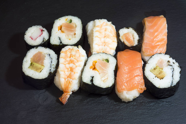 Trozos de sushi en una piedra negra
 - Foto, imagen