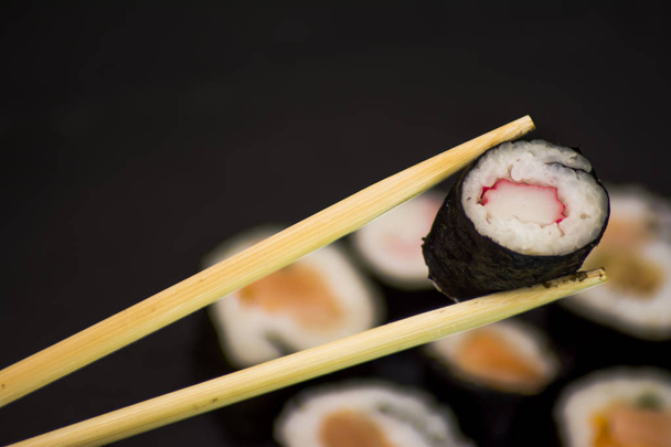 Pedaços de sushi em uma pedra preta
 - Foto, Imagem