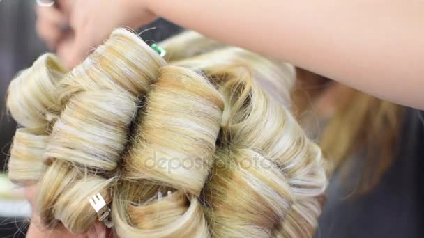 Profesionální vlasy kadeře pro model dívka v salonu krásy nebo ve studiu - Záběry, video