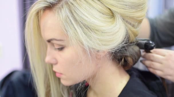 Profesionální vlasy kadeře pro model dívka v salonu krásy nebo ve studiu - Záběry, video