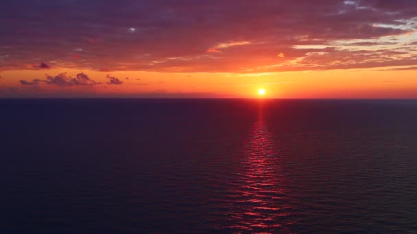 Auringonlasku meren yllä. Aurinko ja oranssi taivas heijastuvat surffauksesta. Hidastettu laukaus. 4K, UHD
 - Materiaali, video