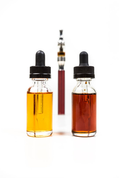 Assorted flavors of vape juice and an ecigarette - Фото, изображение
