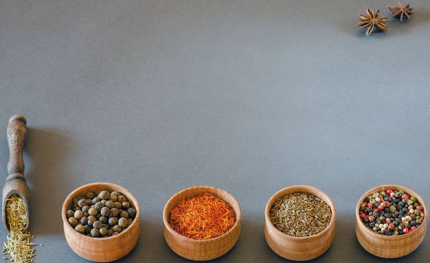 Spices in wooden bowls on a gray background - Photo, Image