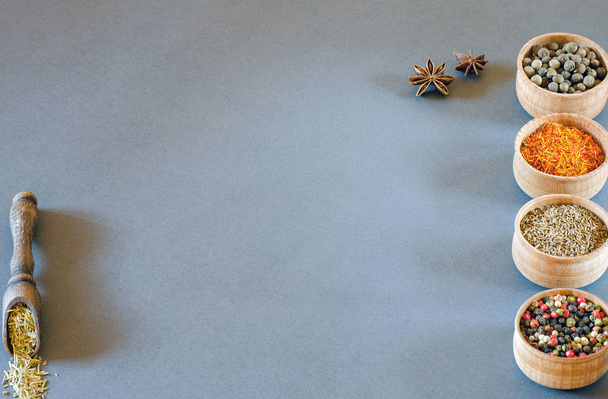 Especiarias em tigelas de madeira em um fundo cinza
 - Foto, Imagem