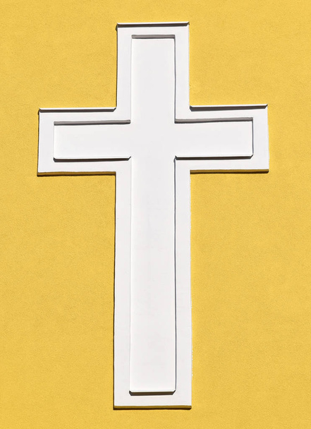Valkoinen risti kirkon seinällä
 - Valokuva, kuva