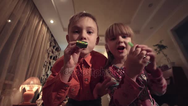 Kinderen met feestmutsen maken lawaai - Video