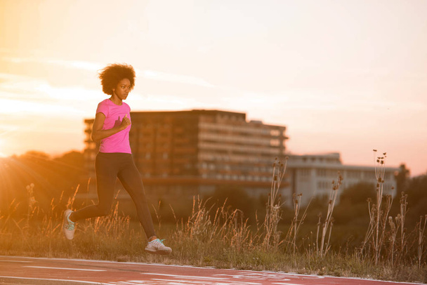 a young African American woman jogging outdoors - Φωτογραφία, εικόνα