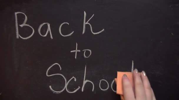 Writing on the blackboard, back to school. The girl writes on a blackboard of back to school - Video, Çekim