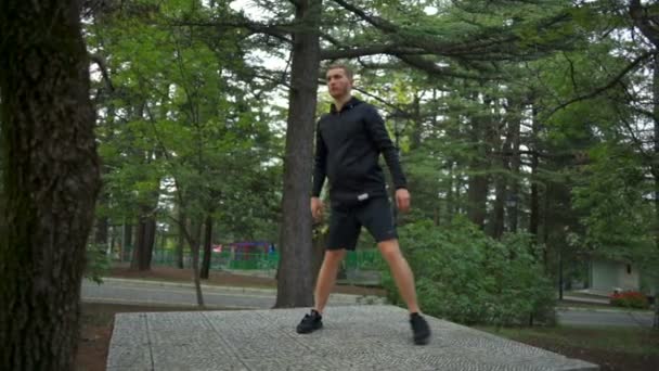 Человек со здоровым образом жизни делает боковые выпады в городском парке замедленной съемки
 - Кадры, видео