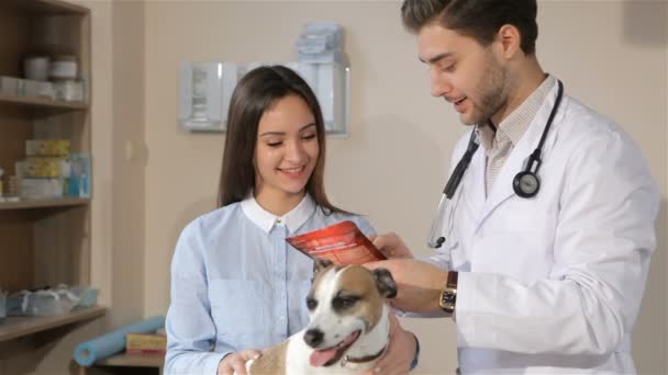 Uros eläinlääkäri kertoo naaras koiran omistajalle hoidosta koiralleen
 - Materiaali, video