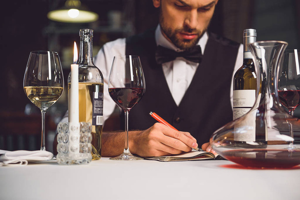 Alcohol critic writing his recommendation - Foto, Imagen