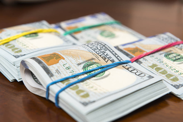Negozi di banconote da cento dollari sul tavolo di legno
 - Foto, immagini