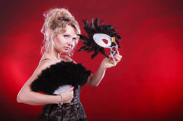Woman holding carnival mask feather fan in hand - Valokuva, kuva