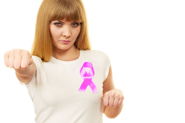 Woman wih pink cancer ribbon on chest punching  - Фото, изображение