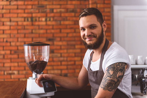 Joyful male bartender working in coffeehouse - 写真・画像