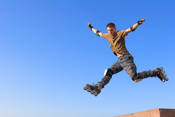 Roller boy jumping from parapet - Fotó, kép