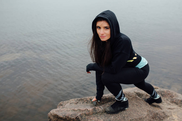 Young fit woman stand on rocks and rest after a hard workout. - Foto, immagini