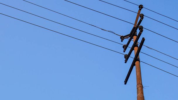 Elektromos pole, vagy villamosenergia-pólus a régi erő vonal a kék ég háttér. - Fotó, kép