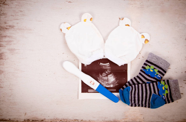 Ultrazvuk s těhotenským testem na dřevěném pozadí - Fotografie, Obrázek