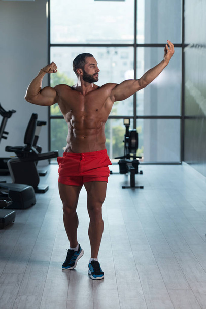 Bodybuilder Posing In The Gym - Foto, immagini