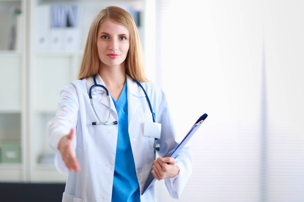 Portrait of woman doctor with folder at hospital corridor - Photo, image