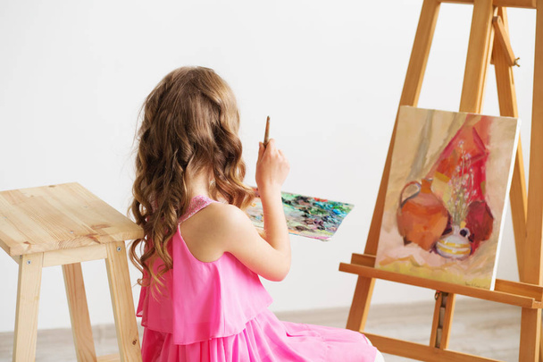 Portrait of a lovely little girl painting a picture in a studio  - Photo, Image
