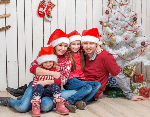 big family in red santa hats near the christmas tree - Fotó, kép