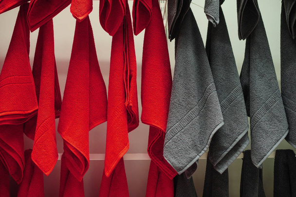 Красные и серые полотенца в магазине на продажу
 - Фото, изображение