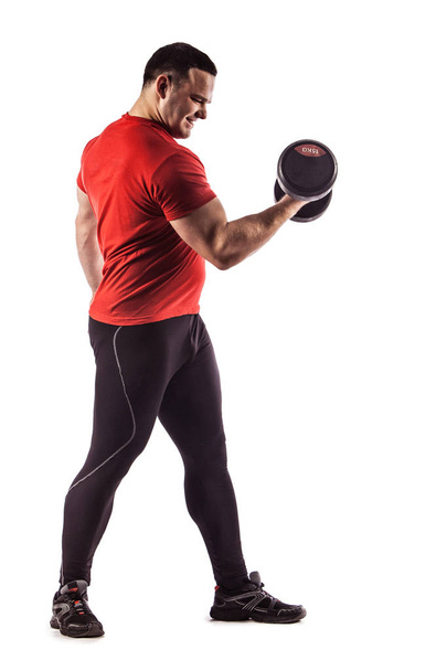Sexy atlético homem mostrando corpo muscular com halteres, isolado sobre fundo branco
. - Foto, Imagem
