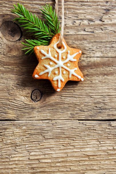 Gingerbread Christmas cookies hanging over wooden background with copy space - festive Christmas pastry and decor, greeting card - Fotografie, Obrázek