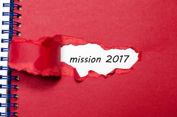 La palabra misión 2017 que aparece detrás del papel roto
 - Foto, Imagen