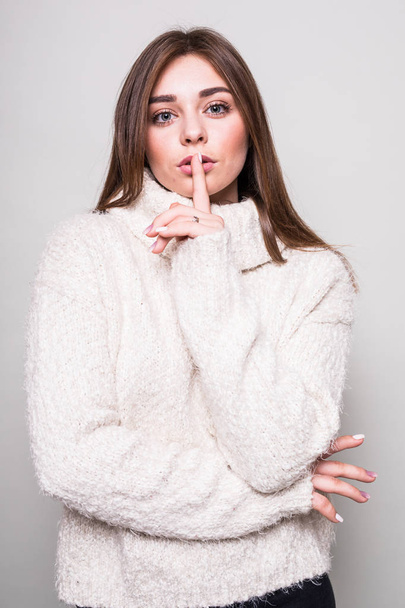 Silence girl  in sweater in studio isolated gray background - Fotó, kép