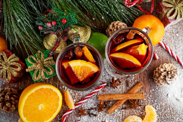 Hot Mulled wine with cinnamon sticks, orange, lime. christmas concept. - Fotografie, Obrázek