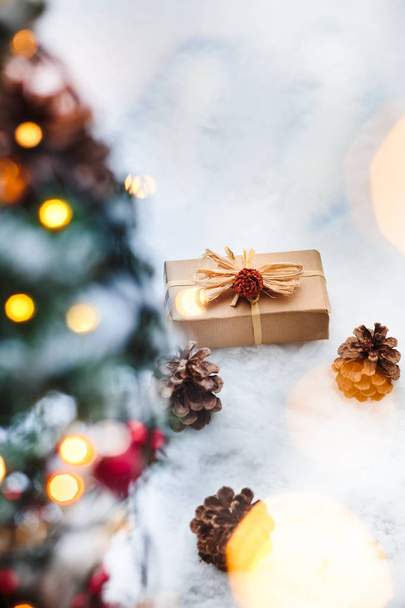 Рождественский подарок положить на снег под елкой
 - Фото, изображение