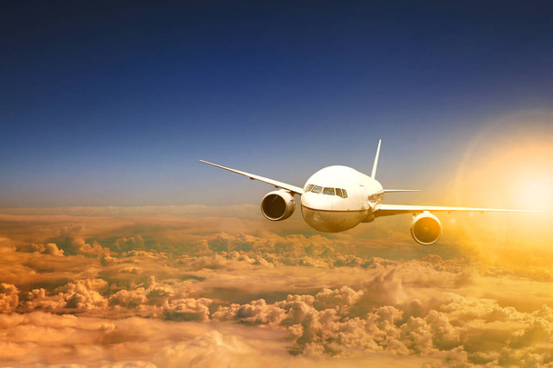 avion volant au-dessus du paysage nuageux et la lumière du soleil derrière
 - Photo, image