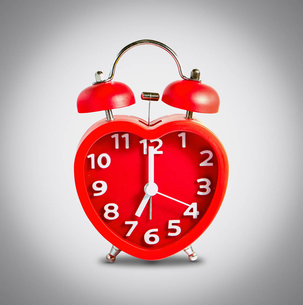 Reloj rojo marca doble campana a las siete en punto
  - Foto, imagen