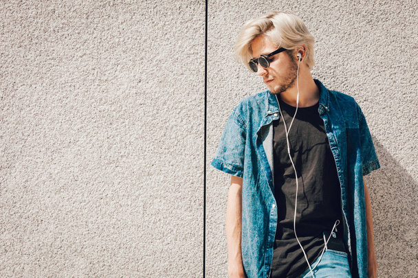 Hipster man listening music through earphones - Foto, immagini