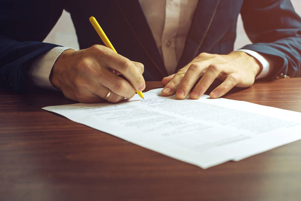 Homem empresário assina documentos com uma caneta
 - Foto, Imagem