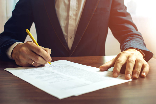 Man businessman signs documents with a pen - Foto, Bild