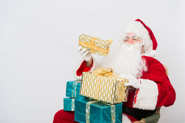 Santa holding many Christmas gifts - Fotografie, Obrázek