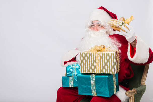 Санта держит много рождественских подарков
 - Фото, изображение