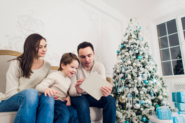 Kerstmis, Kerstmis, winter, geluk, technologie en mensen concept - glimlachend familie met tablet pc - Foto, afbeelding