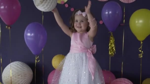 Hezká malá holčička, smát a hrát si s balónkem na narozeninovou oslavu - Záběry, video