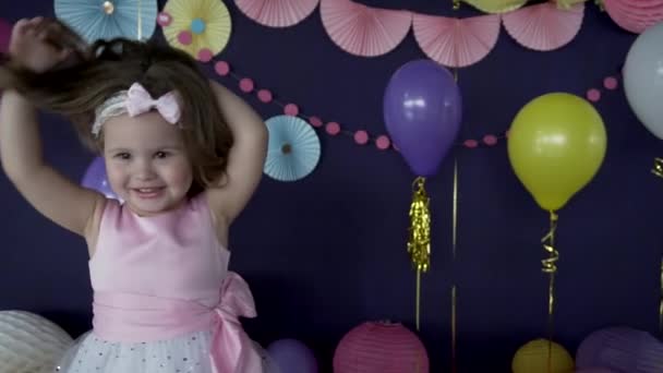 Cute little dziewczynka, śmiechu i zabawy na jej przyjęcie urodzinowe - Materiał filmowy, wideo
