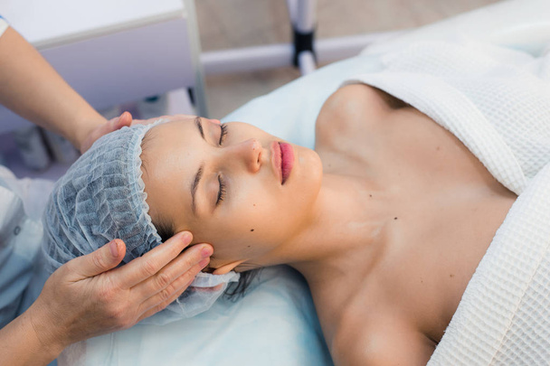 Smiling brunette enjoying a head massage in the health spa - Foto, Imagem