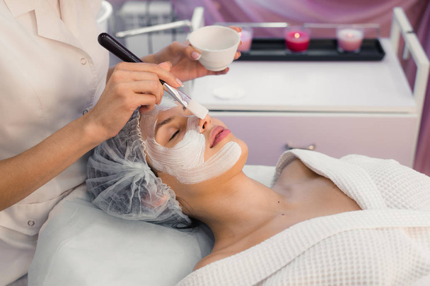Young beautiful woman having spa procedure on her face - 写真・画像