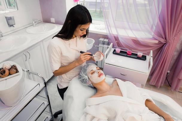 Retrato de mujer joven mientras que el procedimiento cosmético facial en el salón de spa
 - Foto, imagen